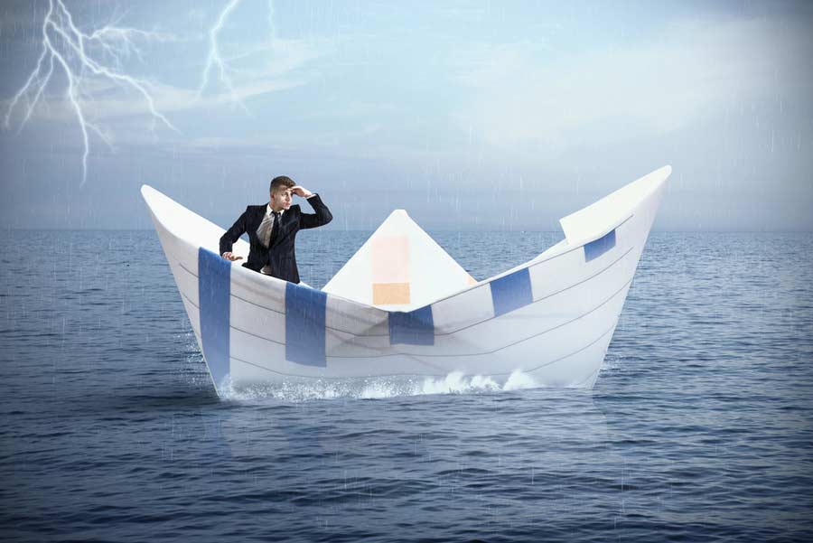 Fotomontage Idee: Mann im Papierboot auf dem Meer (depositphoto.com)